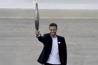 Tony Estanguet, President of Paris 2024, holds a torch with the Olympic flame during the flame handover ceremony at Panathenaic stadium, where the first modern games were held in 1896, in Athens, Friday, April 26, 2024. On Saturday the flame will board the Belem, a French three-masted sailing ship, built in 1896, to be transported to France. (AP Photo/Vasilis Psomas)