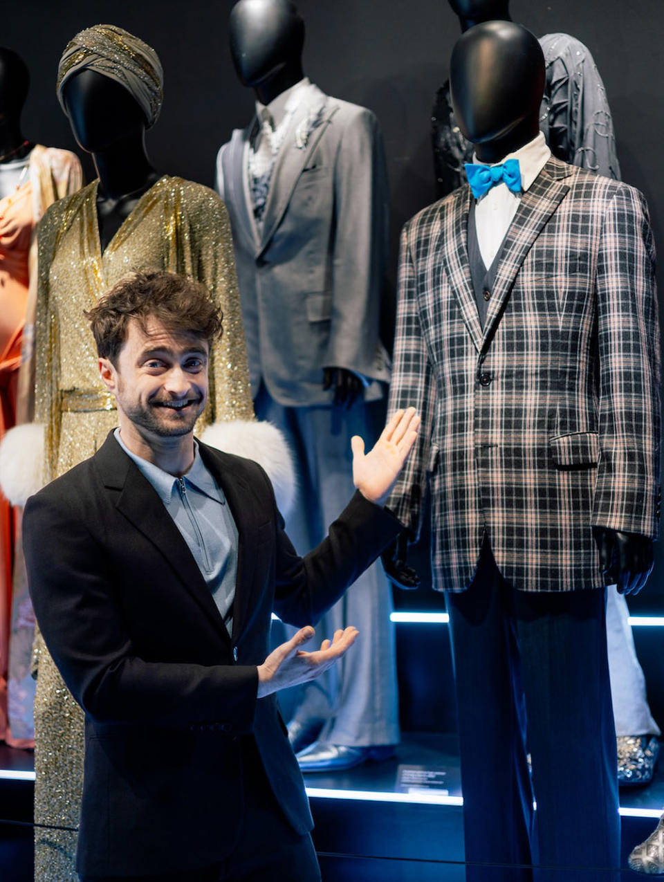 Daniel Radcliffe poses with his iconic suit from How to Succeed in Business Without Really Trying, on display in The Museum of Broadway.