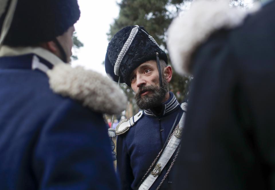 Men dressed as 1812-era Russian soldiers chat as they re-enact a staged battle in the town of Borisov, 70 km (44 miles) east of Minsk, Belarus, Saturday, Nov. 23, 2019, to mark the 207th anniversary of the Berezina battle during Napoleon's army retreat from Russia. (AP Photo/Sergei Grits)