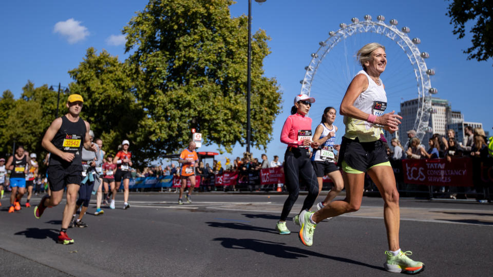  Runners in the London Marathon on the Embankment in Westminster. The Millennium Wheel is in the background. 