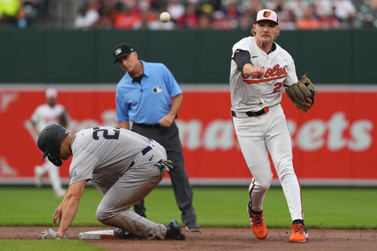 Orioles shortstop Gunnar Henderson turns a double play against the Yankees.