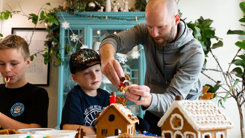 Darin Priday, right, helps his son Zeke, 8, rebuild his fallen gingerbread house at their home in Saratoga Springs on Sunday, Dec. 3, 2023.