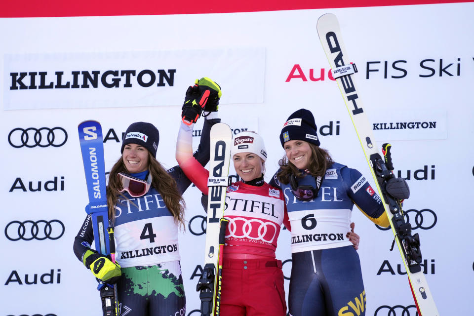 Switzerland's Lara Gut-Behrami, first place, center, and Italy's Marta Bassino, second place, left, and Sweden's Sara Hector, third place, acknowledge applause on the podium following a World Cup giant slalom skiing race Saturday, Nov. 26, 2022, in Killington, Vt. (AP Photo/Robert F. Bukaty)