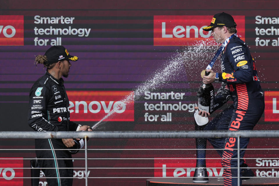 Mercedes driver Lewis Hamilton, of Britain, left, sprays champagne of Red Bull driver Max Verstappen, of the Netherlands, on the podium after the Formula One U.S. Grand Prix auto race at Circuit of the Americas, Sunday, Oct. 22, 2023, in Austin, Texas. (AP Photo/Nick Didlick)