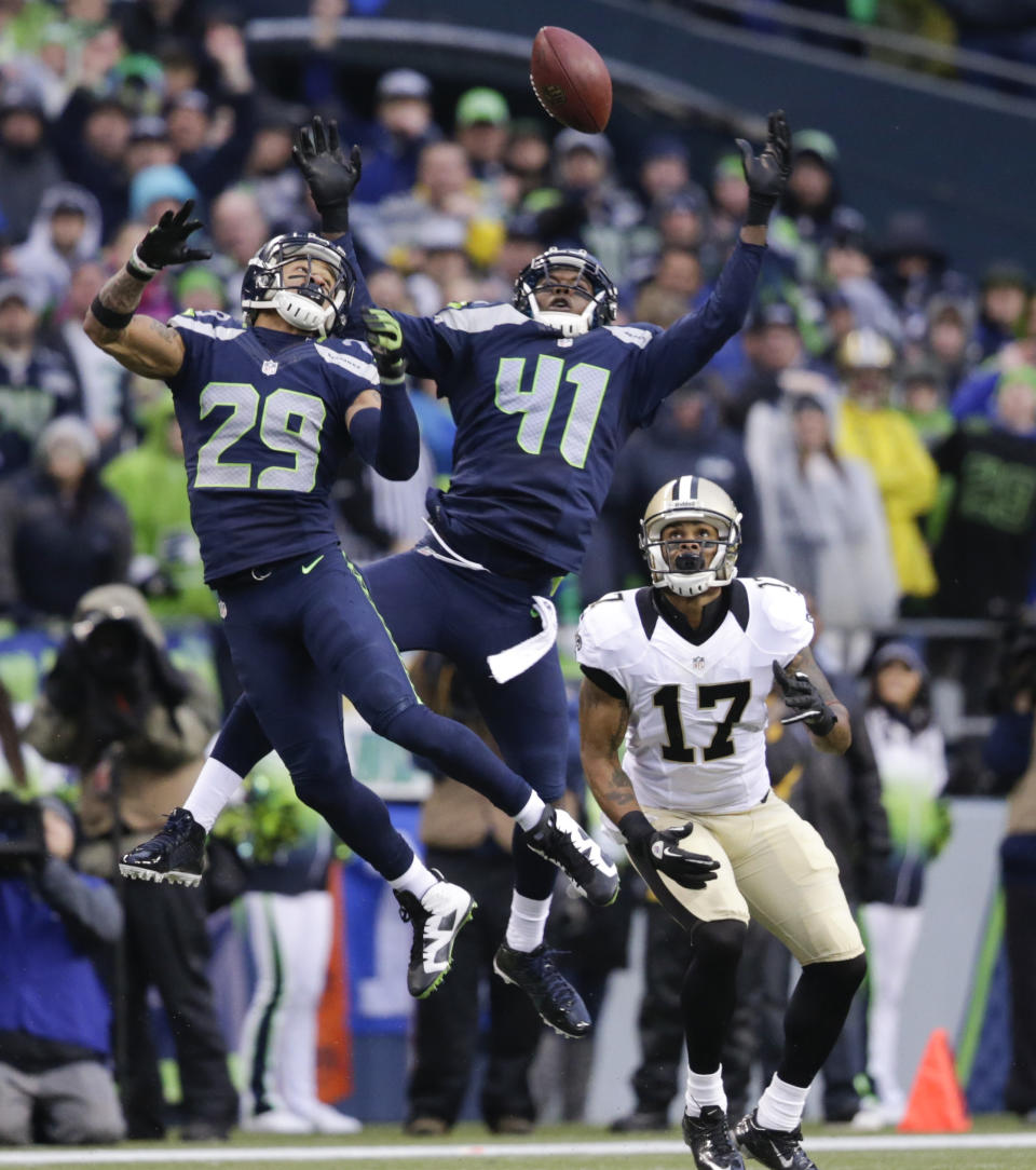 Seattle Seahawks free safety Earl Thomas (29) and cornerback Byron Maxwell (41) jump for a pass that was caught by New Orleans Saints wide receiver Robert Meachem (17) during the fourth quarter of an NFC divisional playoff NFL football game in Seattle, Saturday, Jan. 11, 2014. The Seahawks won 23-15. (AP Photo/John Froschauer)