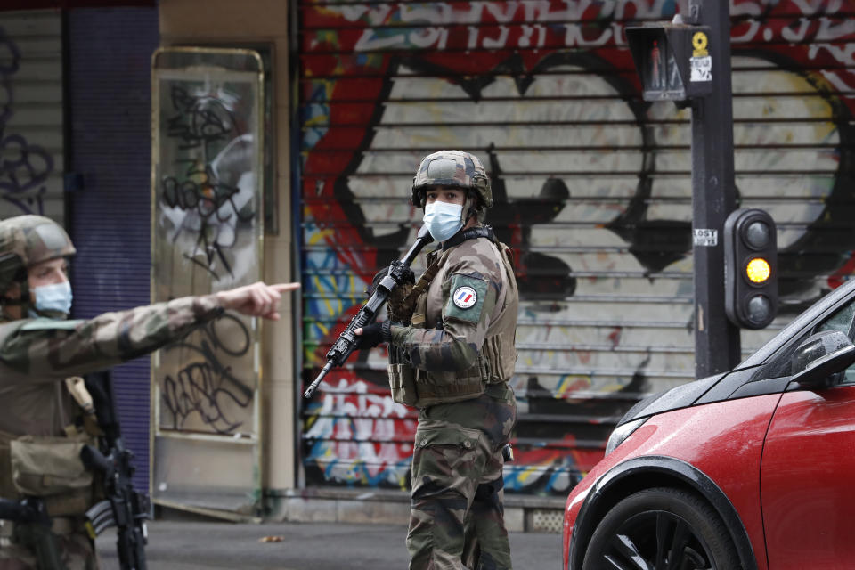 Soldados franceses patrullan por una calle luego de que dos personas resultaron heridas en un ataque con un cuchillo cerca de las antiguas oficinas de la revista satírica Charlie Hebdo, el 25 de septiembre de 2020 en París. (AP Foto/Thibault Camus)