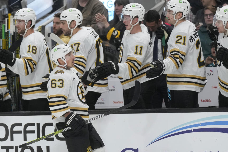 Boston Bruins left wing Brad Marchand (63) is congratulated by teammates after scoring against the San Jose Sharks during the first period of an NHL hockey game in San Jose, Calif., Thursday, Oct. 19, 2023. (AP Photo/Jeff Chiu)