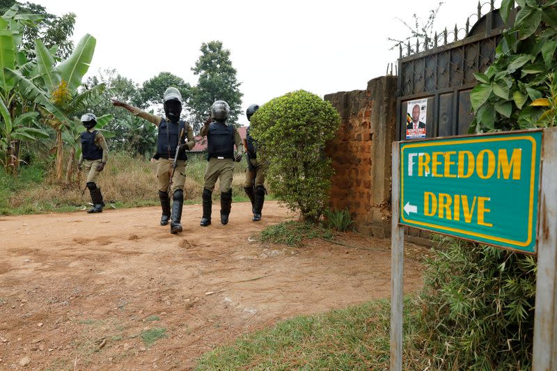 FILE PHOTO: Ugandan police officers order journalists to leave a road leading to the home of Ugandan opposition presidential candidate Robert Kyagulanyi, also known as Bobi Wine, in Kampala