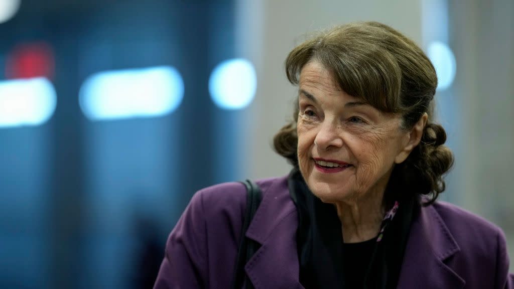 dianne feinstein wearing a purple coat and smiling