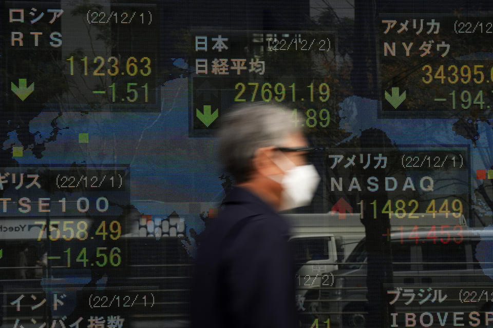 A man walks by monitors showing Japan's Nikkei 225 index and other countries' stock market indexes at a securities firm in Tokyo, Friday, Dec. 2, 2022. Shares retreated in Asia on Friday after a mixed day on Wall Street as optimism over signs the Federal Reserve may temper its aggressive interest rate hikes was replaced by worries the economy might be headed for a recession. (AP Photo/Hiro Komae)