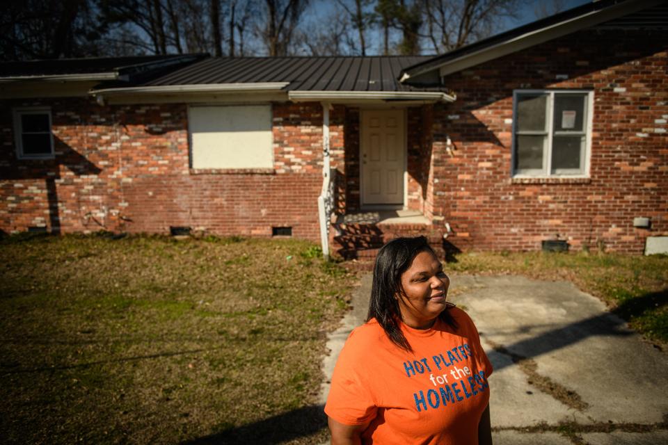 Trisha James stands in front of her childhood home on Ingram Street, which she was taken out of at the age of four and put into the foster care system. James now runs the nonprofit Serving Hope, which helps the homeless.