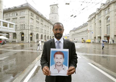 Pakistani exile Haji Anwar Baloch displays a print showing a portrait of his son as he stands in front of the railway station in the north-eastern Swiss city of St. Gallen July 3, 2013. REUTERS/Arnd Wiegmann