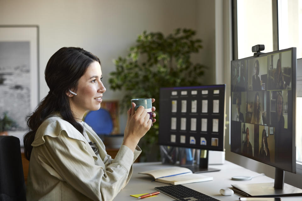 Woman using airpods in a video conference call with multiple colleagues