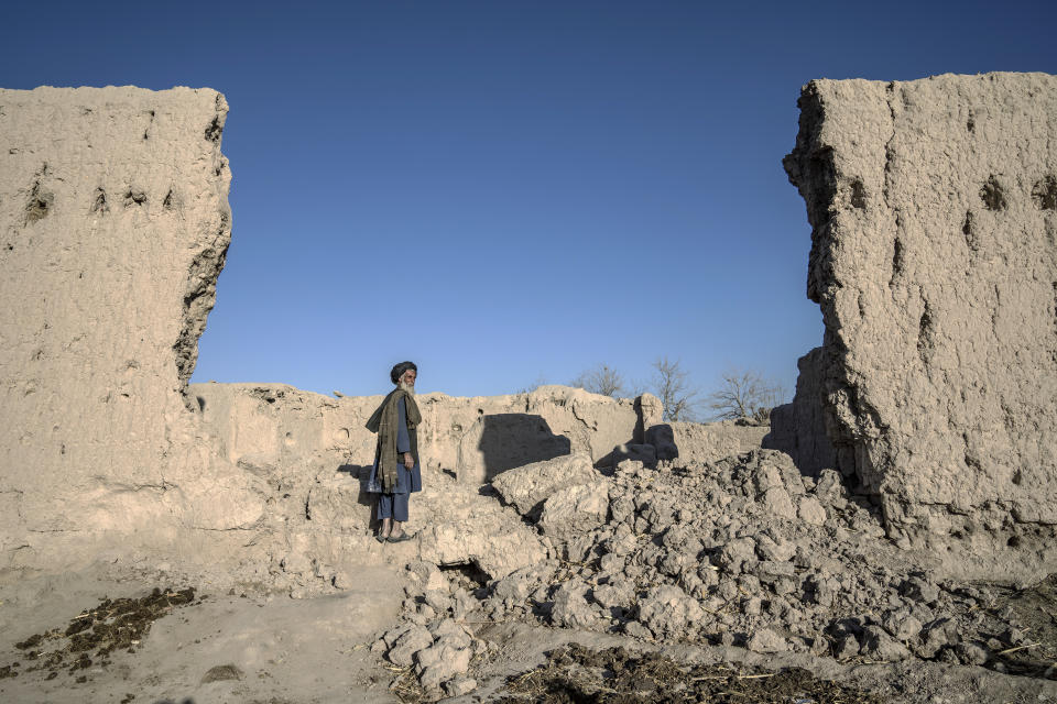 A man stands next to his house that was destroyed by U.S. forces during a raid in a village in a remote region of Afghanistan, on Wednesday, Feb. 22, 2023. In a nearby village, a baby was orphaned during a similar raid in 2019. A U.S. Marine who adopted her claims her parents were foreign fighters. But villagers say they were innocent farmers caught in the fray. (AP Photo/Ebrahim Noroozi)