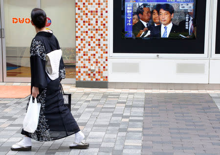 A woman in Kimono watches a TV set showing Japan's Defense Minister Itsunori Onodera in a news report about North Korea's missile launch in Tokyo, Japan, August 29, 2017. REUTERS/Kim Kyung-Hoon