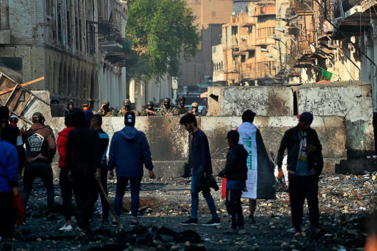 Anti-government protesters gather near barriers in Baghdad: AP