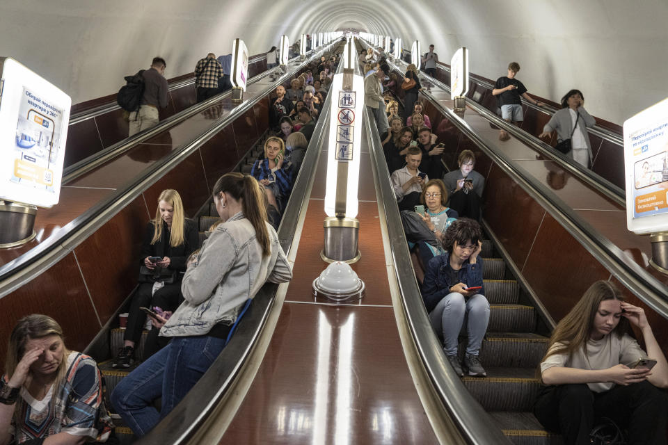 People take cover at metro station during a Russian rocket attack in Kyiv, Ukraine, Monday, May 29, 2023. Explosions have rattled Kyiv during daylight as Russian ballistic missiles fell on the Ukrainian capital. The barrage came hours after a more common nighttime attack of the city by drones and cruise missiles. (AP Photo/Evgeniy Maloletka)