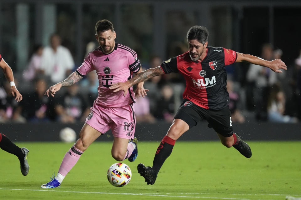 Inter Miami forward Lionel Messi (10) vies for the ball with Newell's Old Boys midfielder Pablo Perez (8) during the first half of a friendly soccer match, Thursday, Feb. 15, 2024, in Fort Lauderdale, Fla. (AP Photo/Rebecca Blackwell)