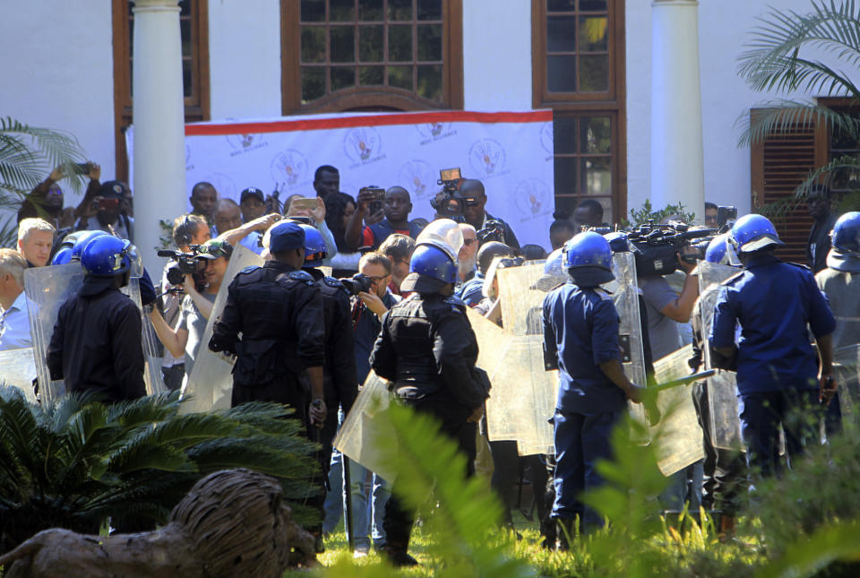 Riot police surround journalists waiting for opposition leader Nelson Chamisa to attend a press conference at a local hotel in Harare, Friday, Aug, 3, 2018. Hours after President Emmerson Mnangagwa was declared the winner of a tight election, riot police disrupted a press conference where opposition leader Nelson Chamisa was about to respond to the election results. (AP Photo/Tsvangirayi Mukwazhi)