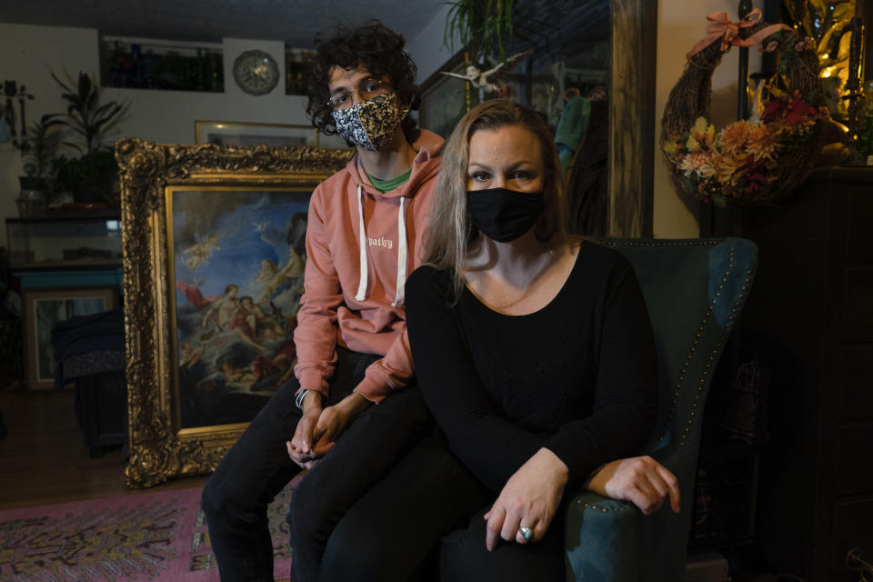 Carey Johnson and her son Fabian Swain are photographed wearing face masks in their Germantown, Md., home on Monday, Nov. 14, 2022. Both Carey and Fabian have recovered from COVID. (AP Photo/Carolyn Kaster)