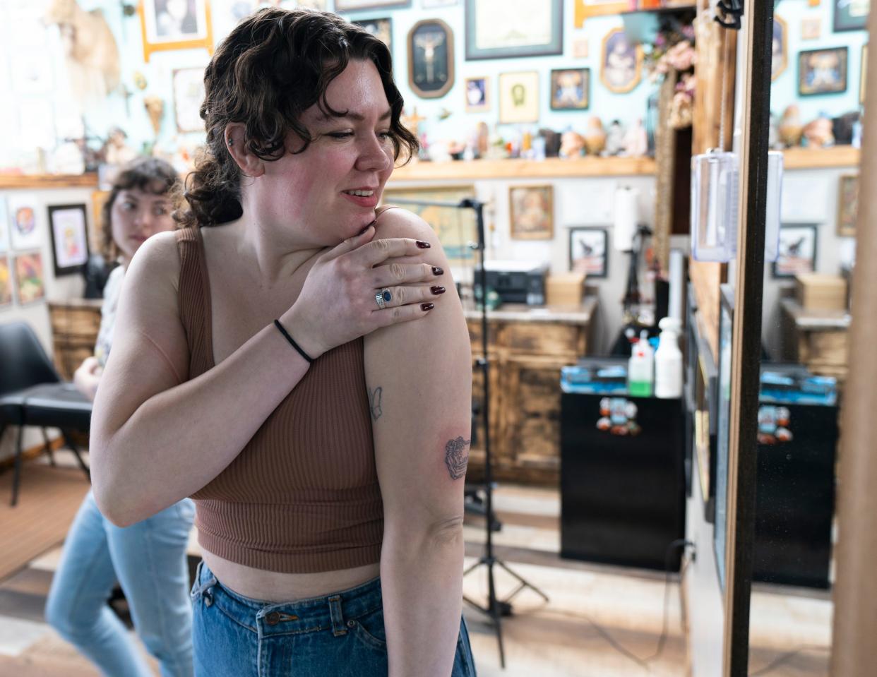 Hannah McHenry, 27 today, takes a look at a new tattoo done by Kay Robertson at Irish Ink Tattoo and Piercing, in the Perry Meridian neighborhood of Indianapolis, Tuesday, March 7, 2023.
