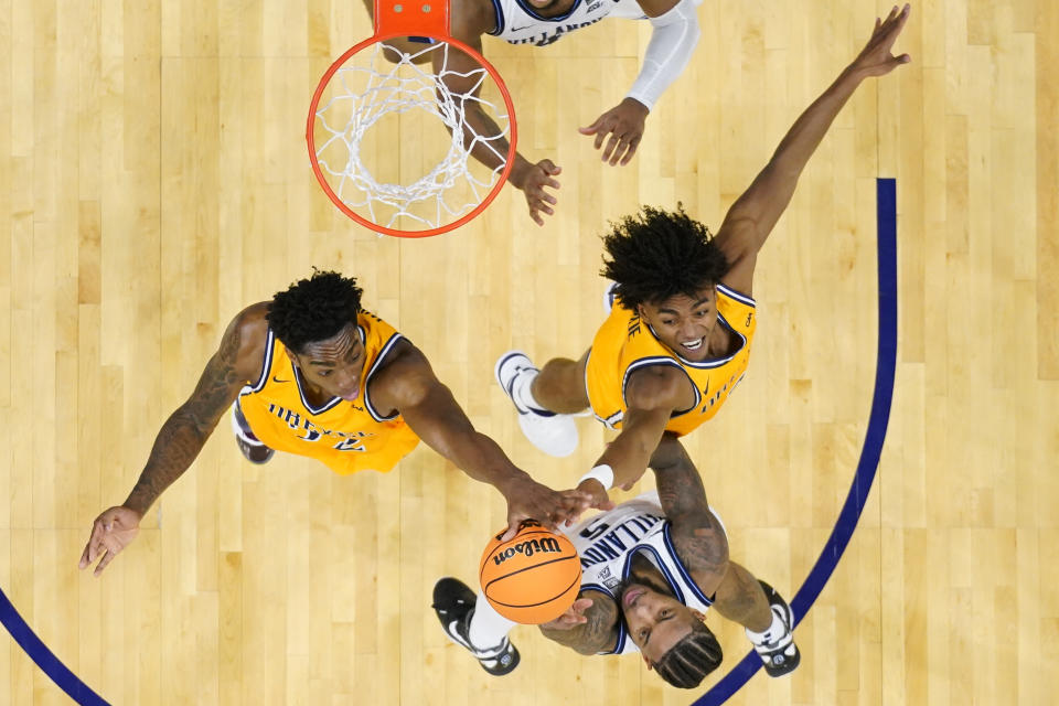 Drexel's Amari Williams, left, Lucas Monroe, right, block Villanova's Justin Moore's shot during the second half of an NCAA college basketball game, Saturday, Dec. 2, 2023, in Philadelphia. (AP Photo/Matt Rourke)