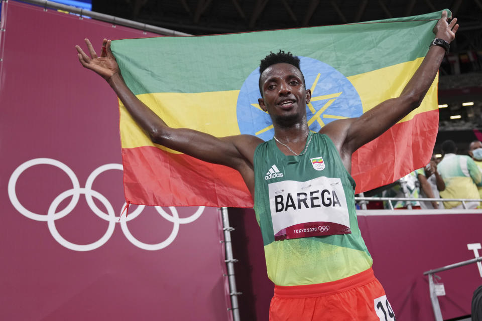 Selemon Barega, of Ethiopia, celebrates after winning the men's 10,000-meters final at the 2020 Summer Olympics, Friday, July 30, 2021, in Tokyo. (AP Photo/Matthias Schrader,Pool)