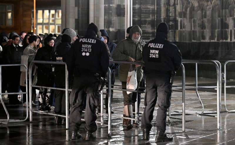 Police officers secure an entrance to Cologne Cathedral. Due to indications of a planned Islamist attack, the police have stepped up security measures. Roberto Pfeil/dpa