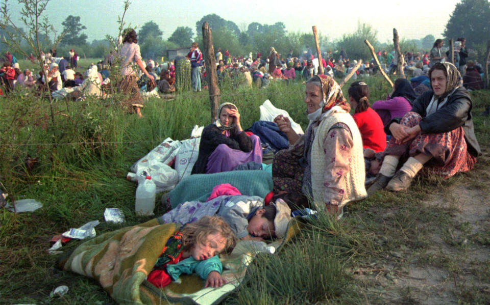 FILE — This July 14, 1995 file photo shows refugees from the overrun U.N. safe haven enclave of Srebrenica who had spent the night outdoors, gathering outside the U.N. base at Tuzla airport. U.N. judges on Tuesday, June 8, 2021 deliver their final ruling on the conviction of former Bosnian Serb army chief Radko Mladic on charges of genocide, war crimes and crimes against humanity during Bosnia’s 1992-95 ethnic carnage. Nearly three decades after the end of Europe’s worst conflict since World War II that killed more than 100,000 people, a U.N. court is set to close the case of the Bosnian War’s most notorious figure. (AP Photo/Darko Bandic, File)