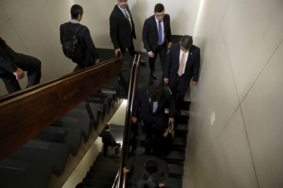 Federal Police leave after searching the office of Senator Fernando Bezerra Coelho, the government leader in the Federal Senate, in Brasilia, Brazil, Thursday, Sept. 19, 2019. Bezerra Coelho is one of the targets of a federal police operation into a possible kick-back scheme allegedly carried out when he was in the Cabinet of former President Dilma Rousseff, according to authorities. (AP Photo/Eraldo Peres)