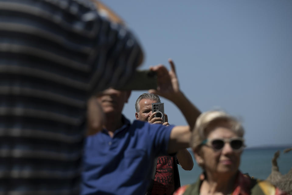 People take images of a collapsed building that killed four people in Palma de Mallorca, Spain, Friday, May 24, 2024. Spanish police say the four people killed when a building housing a bar and restaurant collapsed on the island of Mallorca late Thursday were two German women, a Spanish woman and a Senegalese man. Firefighter department spokesman Eder García told reporters that excess weight on a first-floor terrace may have caused the collapse. Sixteen people were injured and five were said to be in serious condition. (AP Photo/Francisco Ubilla)