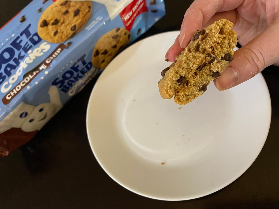 hand holding two pieces of pillsbury chocolate chip cookies