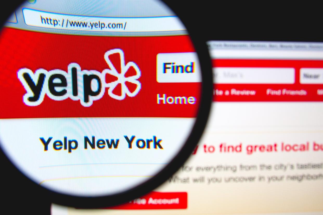 Yelp homepage on a monitor screen through a magnifying glass