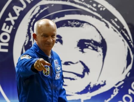 A member of the International Space Station (ISS) crew Jeff Williams of the U.S. gestures in front of a portrait of Yuri Gagarin, the first man in space, during a news conference behind a glass wall at the Baikonur cosmodrome, Kazakhstan, March 17, 2016, ahead of the launch scheduled on March 19. REUTERS/Shamil Zhumatov