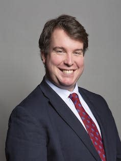 Craig Williams in a red tie and black suit.