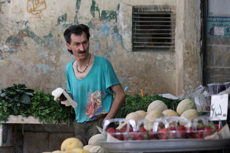 An Iranian man looks at fruits in a fruit shop in Tehran