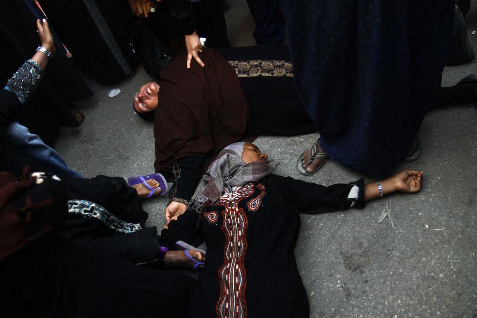 Egyptian women overcome by emotion fall to the ground after a judge sentenced to death more than 680 alleged supporters of the country’s ousted Islamist president over acts of violence and the murder of policemen in the latest mass trial in the southern city of Minya, Egypt, Monday, April 28, 2014. Attorney Ahmed Hefni told reporters outside the court in Minya on Monday that the death sentences first have to be approved by Egypt's mufti, the top Islamic official — a step that is usually considered a formality. (AP Photo/Ahmed Gomaa)