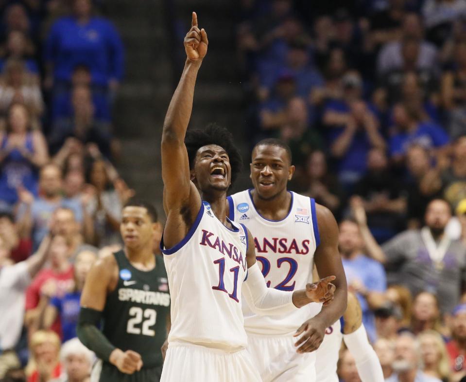 Kansas guard Josh Jackson (11) celebrates a basket with teammate Dwight Coleby (22) in front of Michigan State guard Miles Bridges (22) in the second half of a second-round game in the men's NCAA college basketball tournament in Tulsa, Okla., Sunday, March 19, 2017. (AP Photo/Sue Ogrocki)