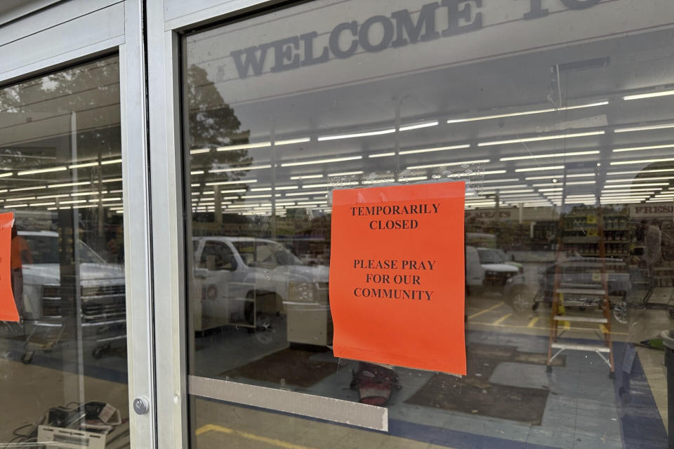 Signs are taped to the front doors of the Mad Butcher grocery store in Fordyce, Ark. on Wednesday, June 26, 2024. The store has been closed in the days following a mass shooting that killed four people, and volunteers in the community have been setting up food distribution sites to help residents. (AP Photo/Andrew DeMillo)