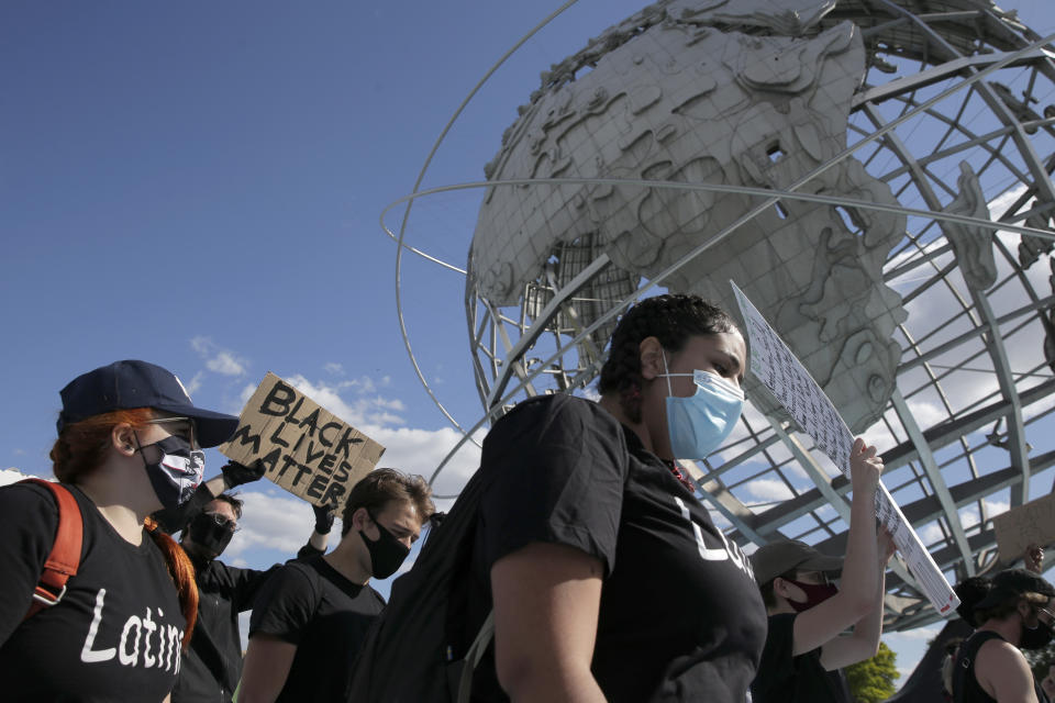 Protesters march a large sculpture of a globe in Flushing Meadows Corona Park in the Queens borough of New York, Sunday, May 31, 2020. Demonstrators took to the streets of New York City to protest the death of George Floyd, a black man who was killed in police custody in Minneapolis on May 25. (AP Photo/Seth Wenig)