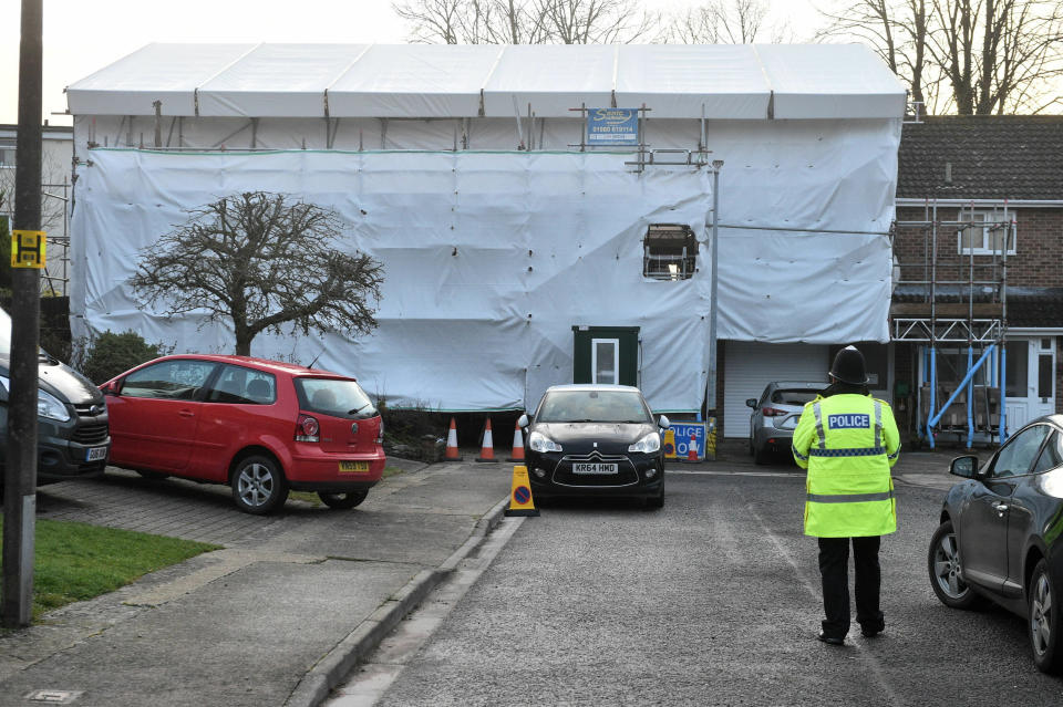 A police officer stands outside the home of former Russian spy Sergei Skripal on the first anniversary of his poisoning, in Salisbury, England, Monday March 4, 2019, as the house remains shrouded in scaffolding, but has been declared safe after decontamination work. Former Russian spy Sergei Skripal and his daughter, Yulia, were found collapsed on a park bench in the city, March 4, 2018, after they were poisoned with the deadly nerve agent Novichok. (Ben Birchall/PA via AP)