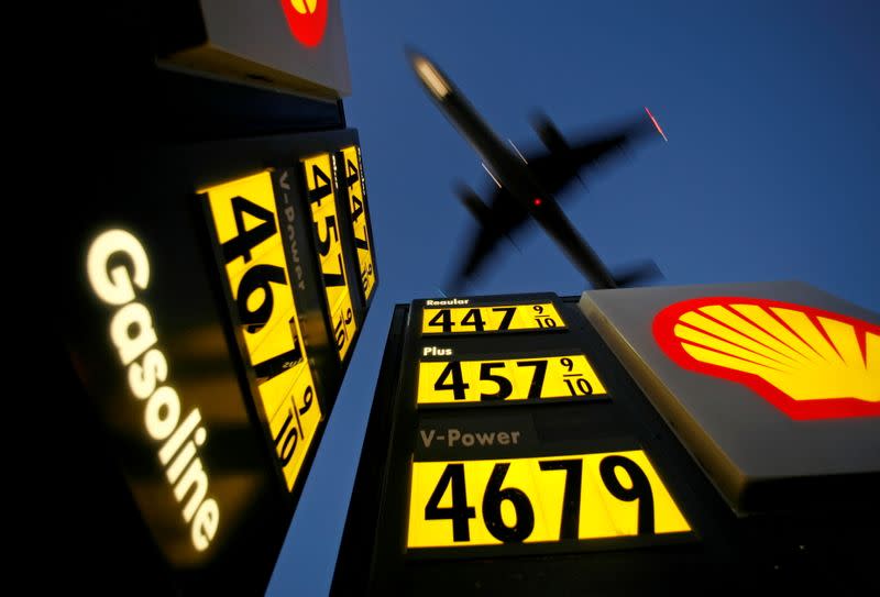 FILE PHOTO: Gasoline prices are advertised at a gas station near Lindbergh Field as a plane approaches to land in San Diego