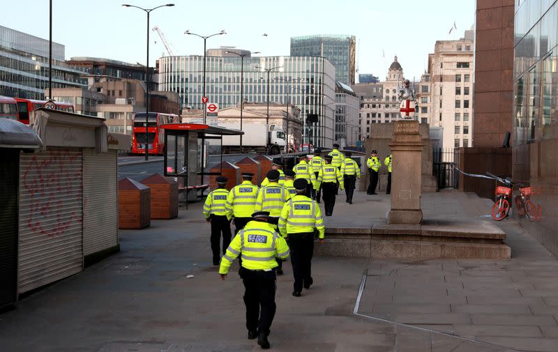 Oficiales de policía caminan cerca de la escena del apuñalamiento en el Puente de Londres, en el que dos personas fueron asesinadas, en Londres, Reino Unido