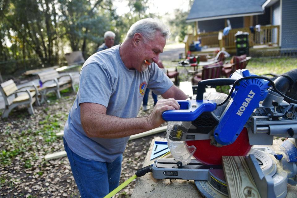 Volunteer Derek Holmes cuts wood to be made into bench seating for The Villages of Hope, a tiny-home community in Jacksonville for human-trafficking survivors.