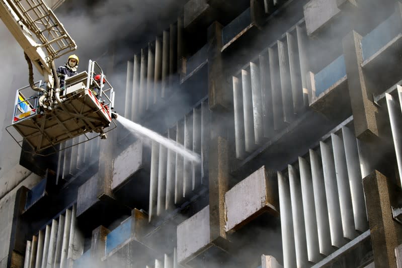 Firemen hose down a burning building in Baghdad