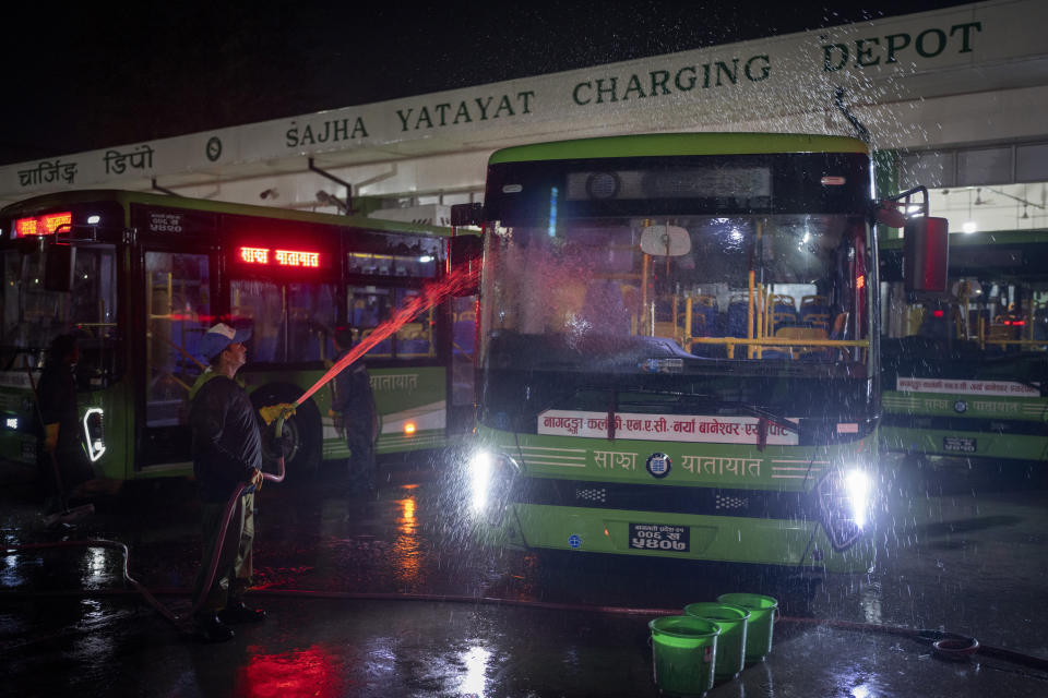 A worker washes a public transport bus at an electric charging station in Kathmandu, Nepal, Friday, May 10, 2024. Nearly all of the electricity produced in Nepal is clean energy, most of it generated by river-fed hydro-electricity. Thanks to that abundant source of power, the country is quickly expanding charging networks and imports of EVs have doubled in each of the past two years, according to customs data. (AP Photo/Niranjan Shrestha)