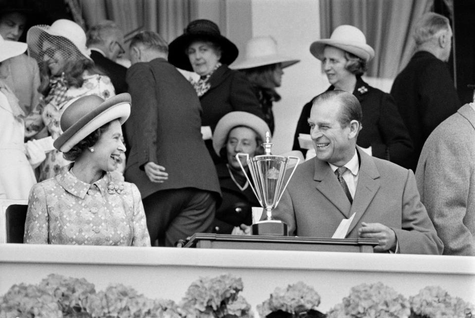The couple share a laugh in May 1972 as they attend a horse race at Longchamp racecourse, outside Paris, during their five-day official visit in France. (Photo credit should read STAFF/AFP via Getty Images)