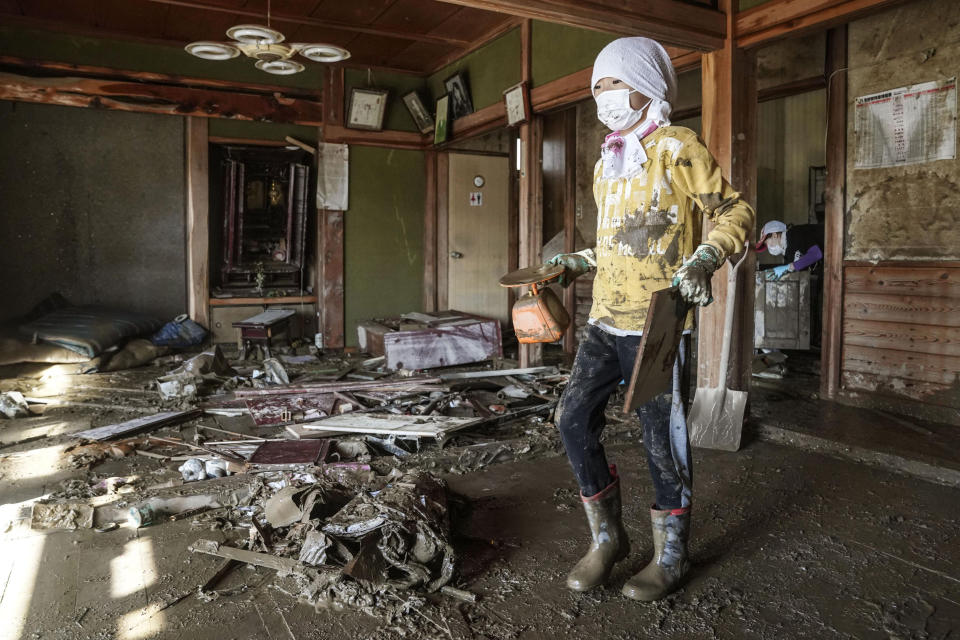 A boy cleans a house devastated by Typhoon Hagibis, in Nagano, central Japan Wednesday, Oct. 16, 2019. The typhoon hit Japan's main island on Saturday with strong winds and historic rainfall that caused more than 200 rivers to overflow, leaving thousands of homes flooded, damaged or without power. (Koki Sengoku/Kyodo News via AP)