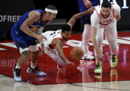 Denver Nuggets forward Aaron Gordon, left, and Portland Trail Blazers guard CJ McCollum, center, and center Jusuf Nurkic after a loose ball during the first half of an NBA basketball game in Portland, Ore., Wednesday, April 21, 2021. (AP Photo/Steve Dykes)