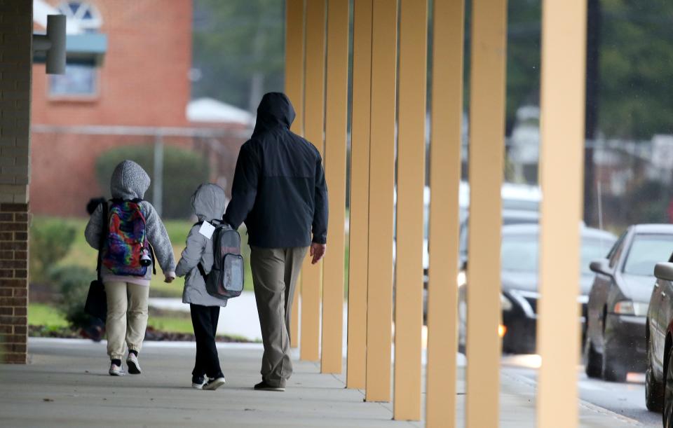 Students, teachers and parents arrive at Martin Luther King Jr. Elementary in Tuscaloosa on Thursday, Jan. 20, 2022. The city system will close schools on Friday and conduct virtual classes on Monday because of a COVID-19 spike.